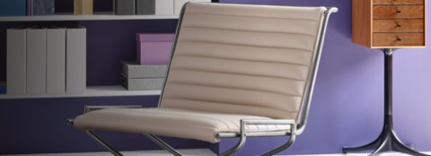 Close-up on the ribbed seat and lower back of a Sled lounge chair with ivory-colored leather upholstery, viewed at an angle.
