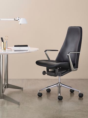 An executive workpoint featuring a black leather Taper office chair and an MP Table with a stone top.