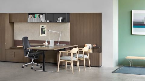 An executive office featuring Geiger Rhythm Casegoods, a black leather Taper office chair, and two Crosshatch Side Chairs.