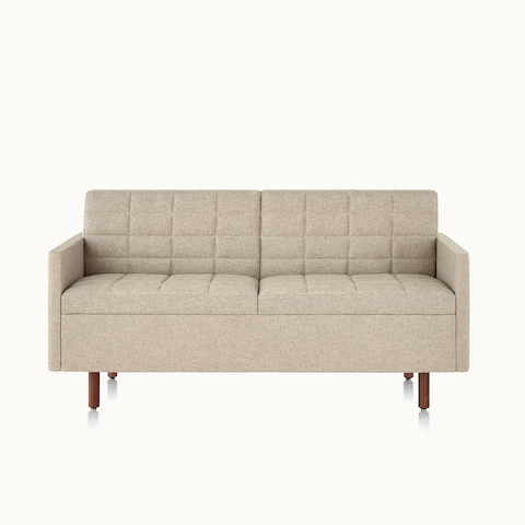 A Tuxedo Classic settee with bone-colored quilted upholstery, viewed from the front.