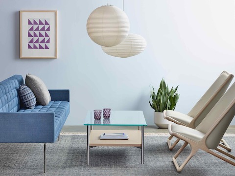 A sitting area featuring a blue Tuxedo Component sofa, two Scissor lounge chairs with ivory-colored leather upholstery, and a Layer coffee table.