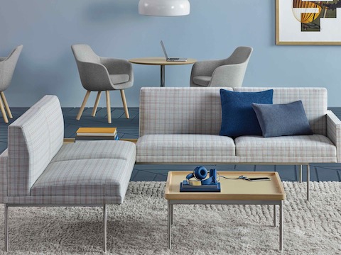 A lounge featuring Saiba Side Chairs in the background and Tuxedo Component settees with a Tuxedo Component coffee table in the foreground.