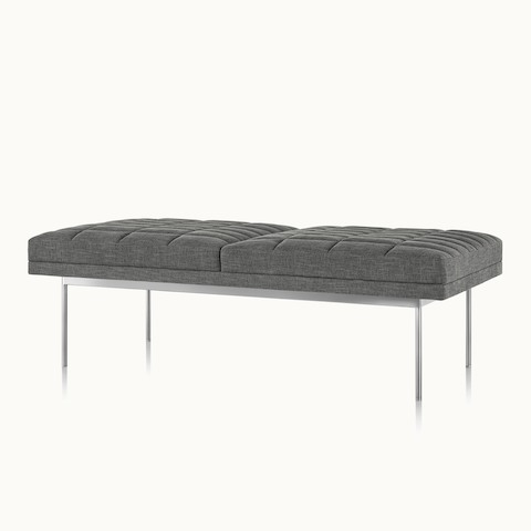 Angled view of a quilted Tuxedo Component bench upholstered in gray fabric.