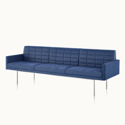 Angled view of a quilted Tuxedo Component sofa upholstered in blue fabric.