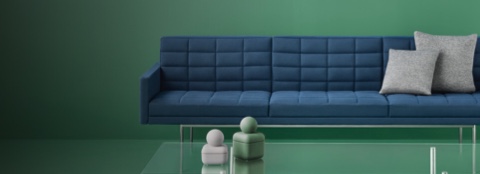 A quilted Tuxedo Component sofa with blue upholstery and two gray accent pillows, viewed from the front.