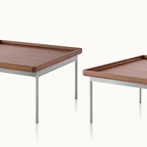 Partial view of rectangular and square Tuxedo Component occasional tables, both with a medium wood finish and steel-plated legs.