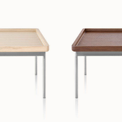 Partial view of two Tuxedo Component occasional tables with steel-plated legs, one with a light wood top and the other with a medium wood top.