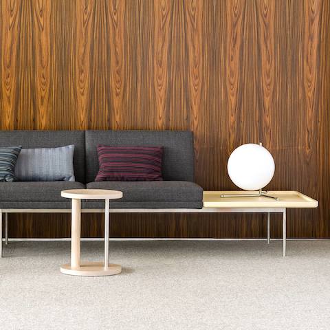 A rectangular Tuxedo Component occasional table attached to the end of a Tuxedo Component sofa with gray upholstery.