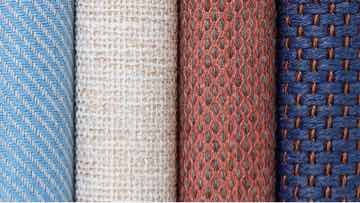 A stack of blue, white, and grey Geiger Textiles from various collections.