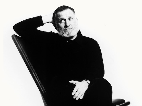 Black-and-white image of product designer Ward Bennett sitting in a Scissor Chair.