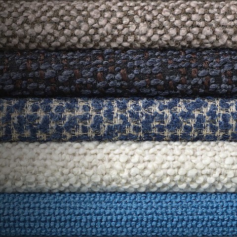 A stack of blue and neutral textiles from the Jolie Collection.